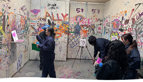 Group of people in a room covered in graffiti